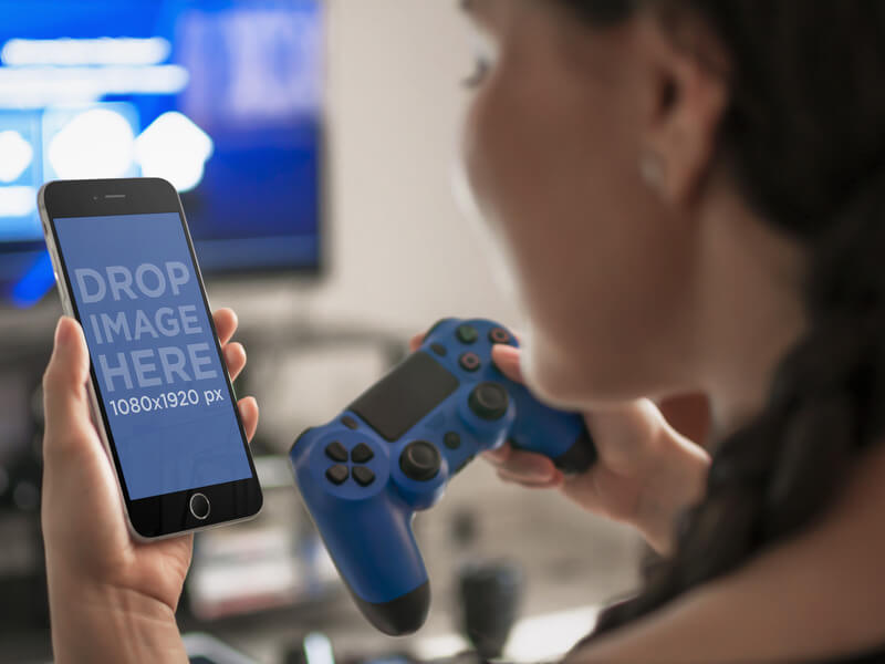 Kobieta grająca na PlayStation 4 patrząc na szablon makiety iPhone'a 6