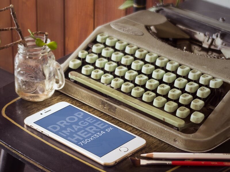 Makieta złotego iPhone’a 6 obok zabytkowej maszyny do pisania