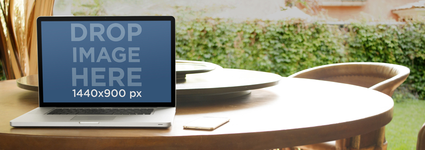 Mockup per laptop con un Macbook su un tavolo da pranzo nell'immagine del palcoscenico di Garden Placeit