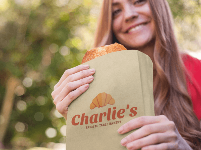 Machetă de pungă de hârtie cu o tânără care mănâncă o patiserie