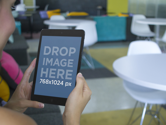 Junge Dame mit einem schwarzen iPad in einem Creative Office Placeit Stage Image