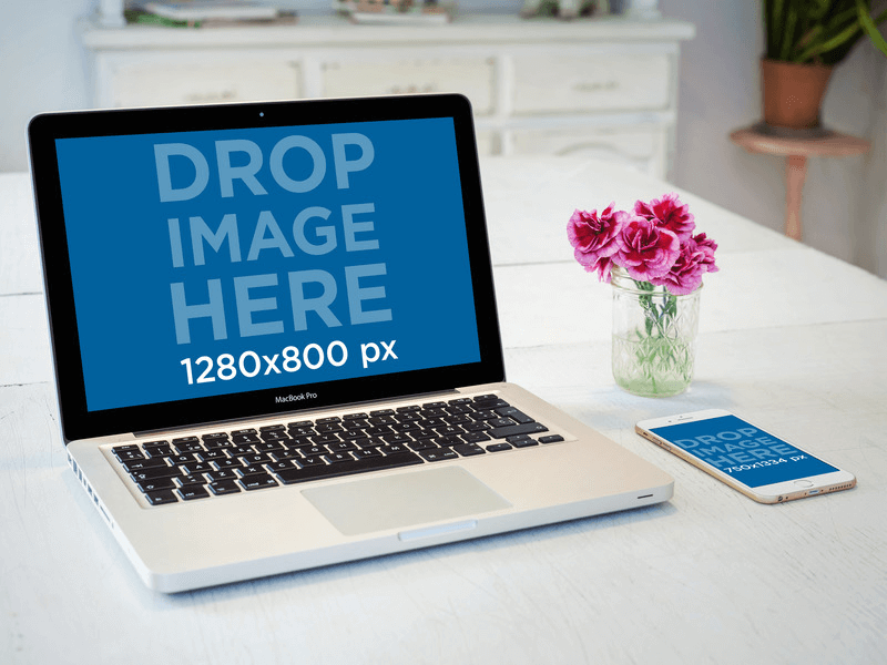 iPhone 6 的樣機躺在木桌上的 Macbook Pro 旁邊