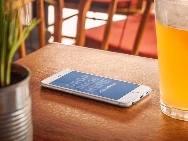 Mockup del prodotto, iPhone 6 su un tavolo di legno accanto a un'immagine di scena di Beer Placeit