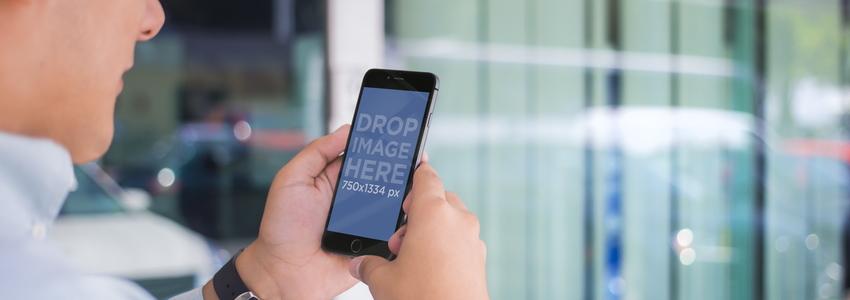 iPhone 6 Placeit ステージ イメージを使用して窓の前に立っている若い男性のモックアップ