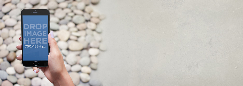 iPhone 6 小石の床の上に iPhone を保持している女性のストックフォト Placeit Stage Image