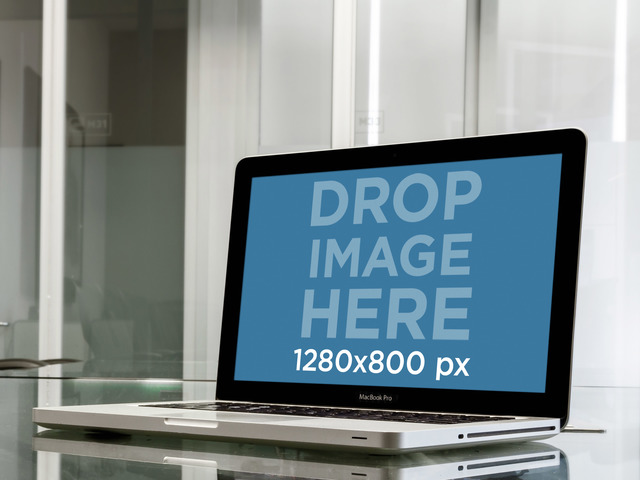 Maquette de l'appareil Macbook Pro sur un bureau en verre dans l'image de la scène Office Placeit