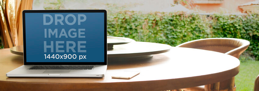 Mockup per laptop con un MacBook su un tavolo da pranzo in giardino