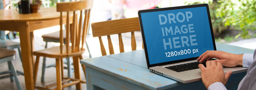 MOCKUP DEL COMPUTER PORTATILE DI UN UOMO D'AFFARI CHE UTILIZZA MACBOOK PRO IN UN PICCOLO RISTORANTE