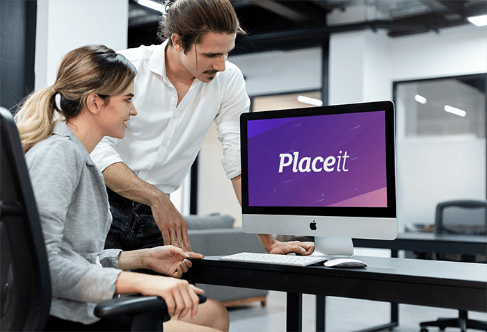 Uomo che allena un collega che lavora su un modello Imac A20989