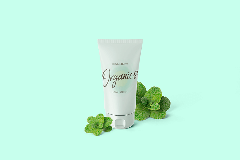 新鮮なミントの葉に囲まれた化粧品のチューブのモックアップ