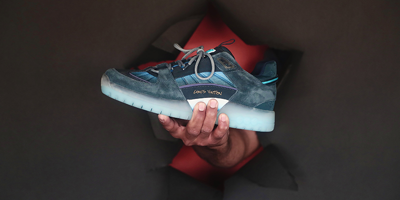 Мужчина держит кроссовки Louis Vuitton ограниченной серии.