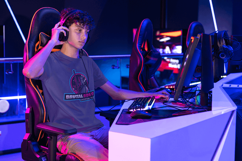 T-Shirt-Modell mit einem Mann in einem Gaming Center