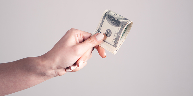 数百ドル札を持っている手