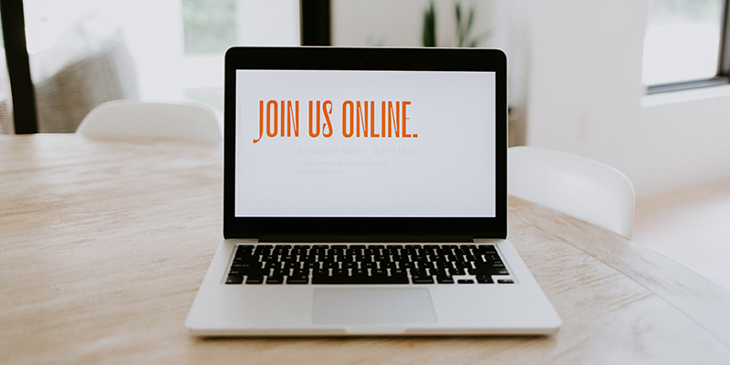 薄茶色のテーブルに置かれた Mac book の画面に表示されているオンライン メッセージに参加してください