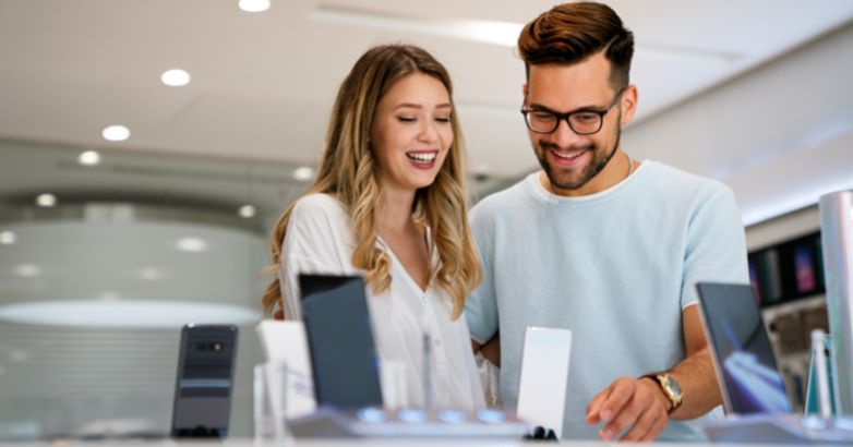 Um casal de noivos está comprando um novo smartphone e pode sentir as vibrações da marca durante a fase de compra.