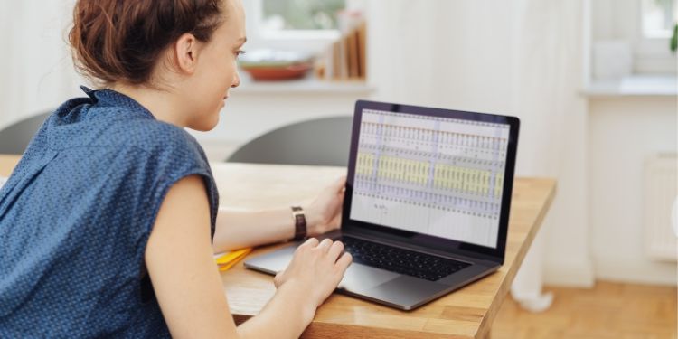 Mulher olhando para planilhas matemáticas em seu computador