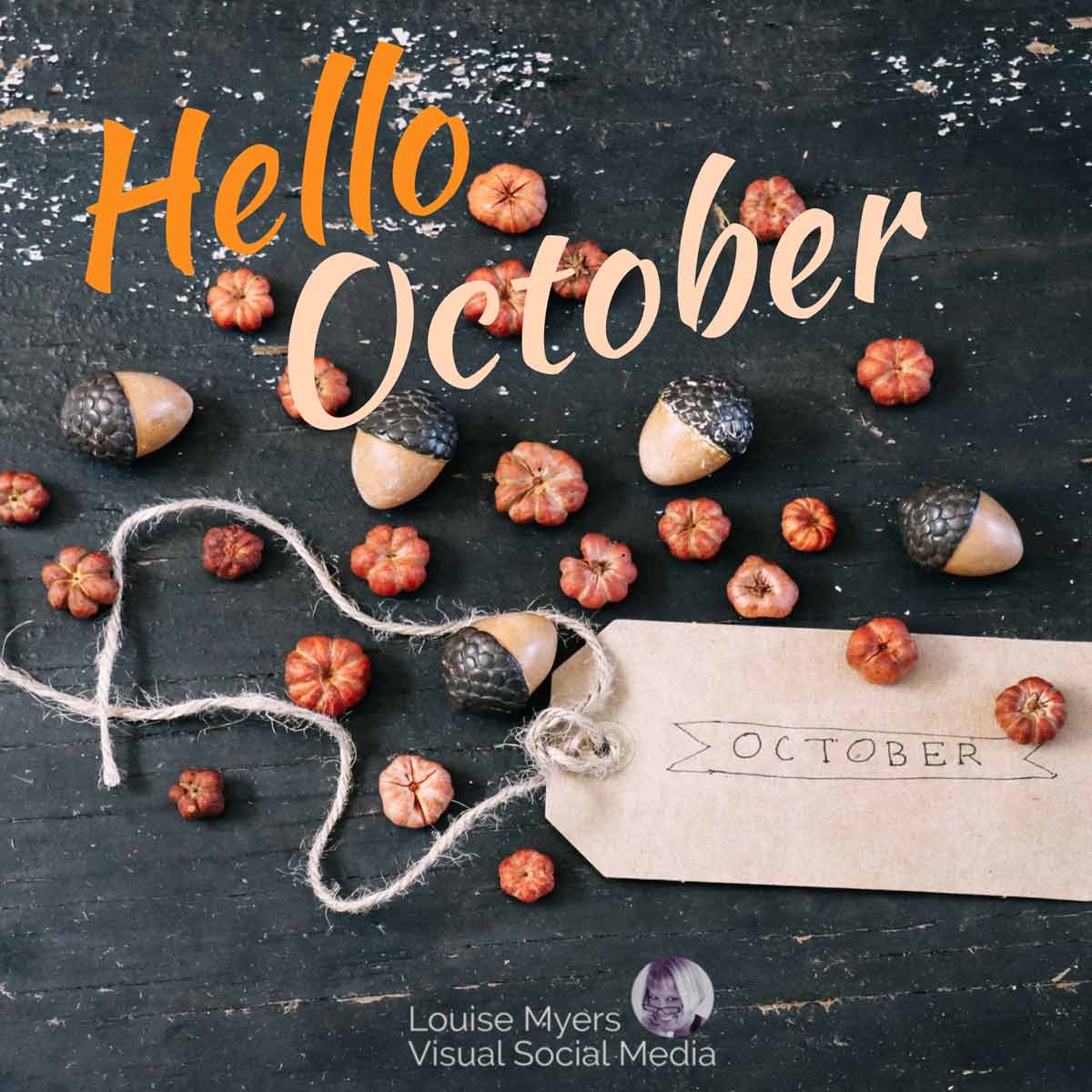 โต๊ะไม้ที่ผุกร่อนกับลูกโอ๊กและฟักทองจิ๋วกล่าวสวัสดีเดือนตุลาคม