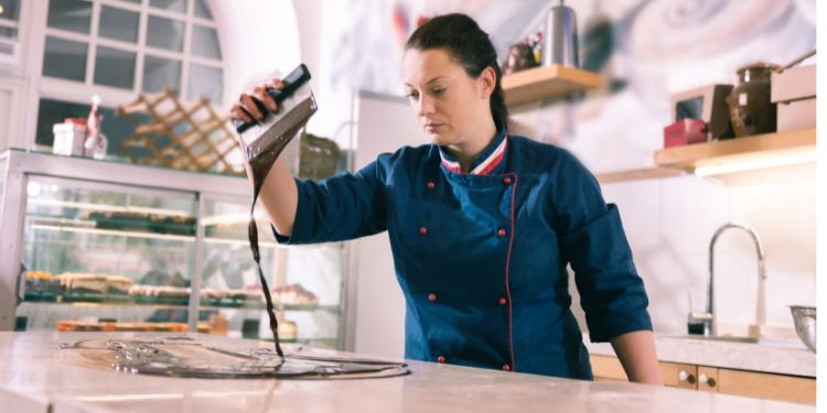 Chocolatier arrangiert Schokolade auf einer Theke