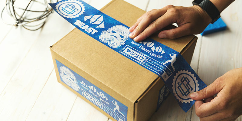 茶色のパッケージにシールテープを貼る