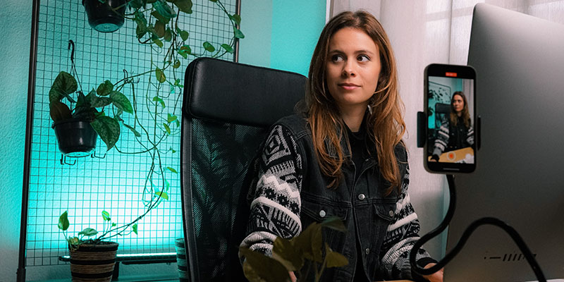 O tânără care face un videoclip TikTok pe biroul ei