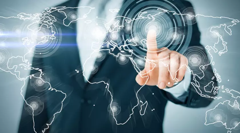 Un homme d'affaires pointe du doigt une carte du monde d'où commence la génération de prospects pour sa startup.