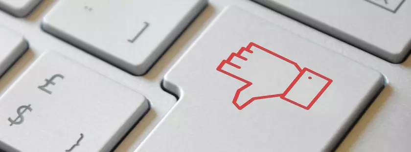 Um close-up de um sinal vermelho de polegar para baixo em um teclado.