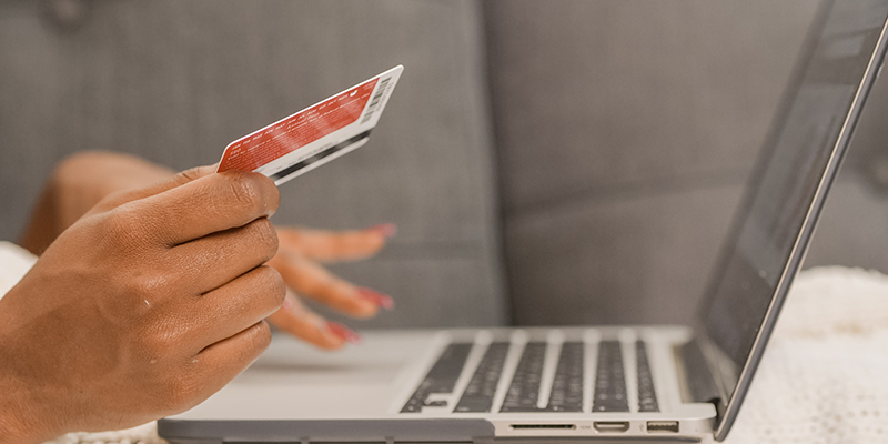 Orang yang memegang kartu kredit melakukan belanja online