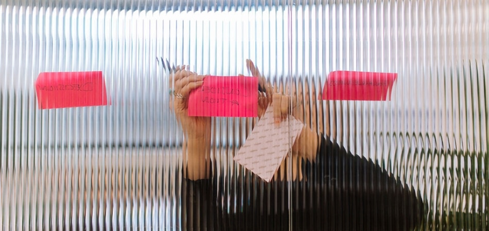 Des notes autocollantes ajoutées à une salle de réunion en verre